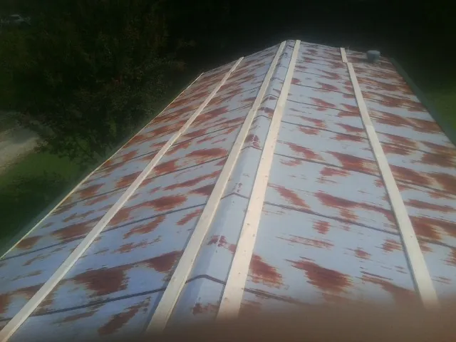 Rusted metal roof panels with new wood purlins before replacement — Storm Damage Roof Repair in New Vienna by Roofing Brothers