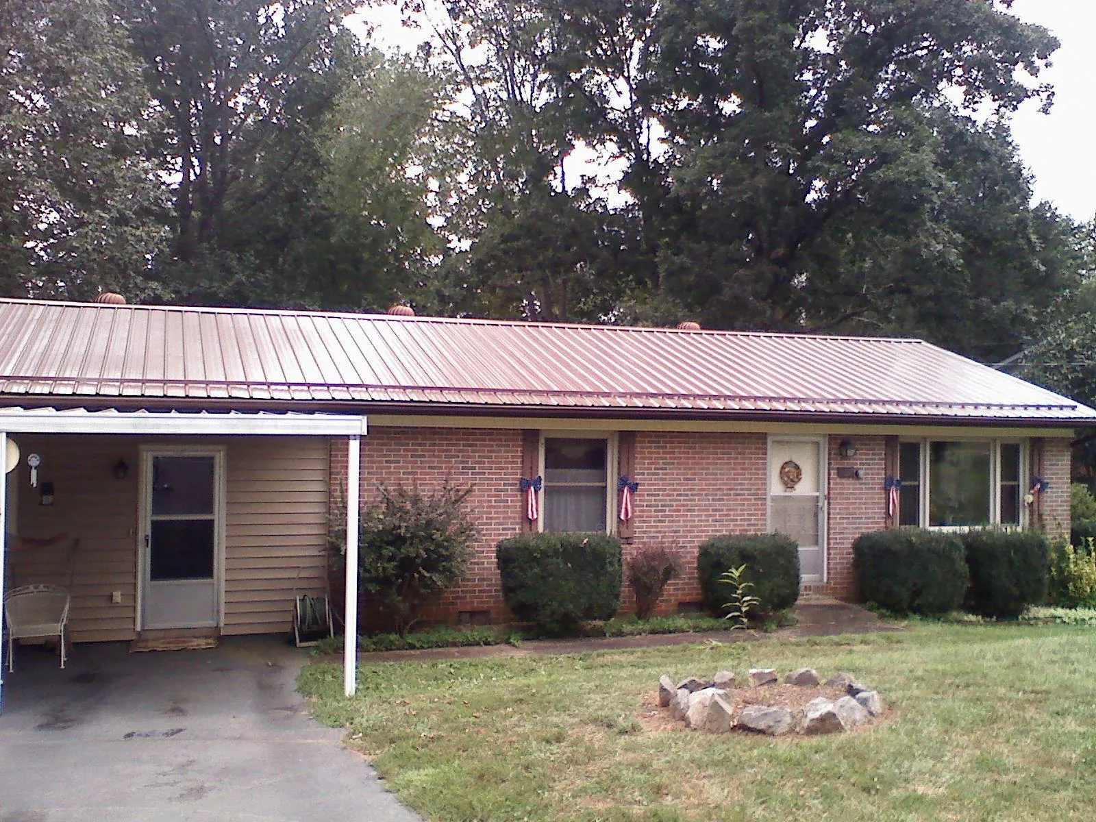 Bronze metal roof and carport on a brick ranch home — Roof Repair work by our crew in New Vienna